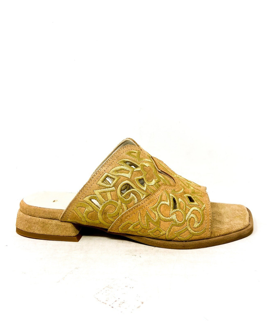 Tan sandal with intricate cut-out design on a white background
